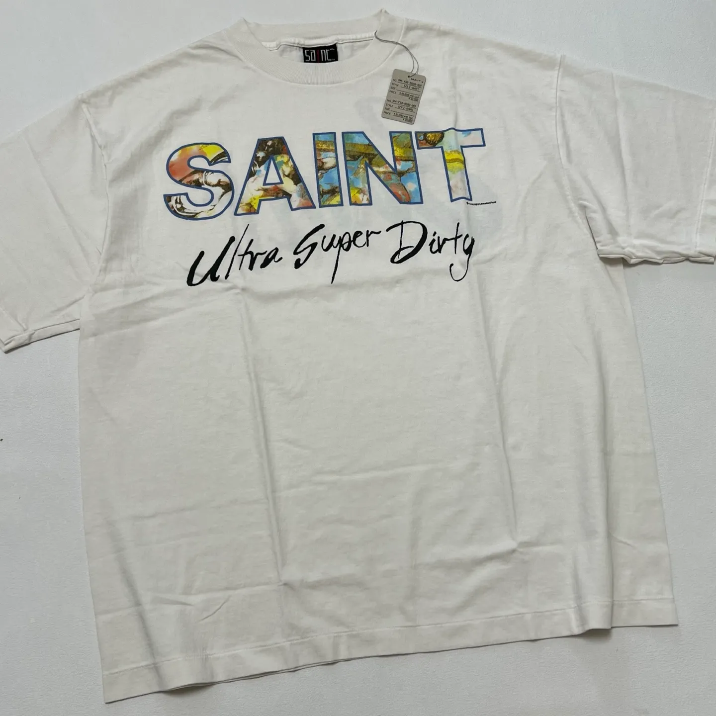 SAINT Mxxxxxx SS TEE/SUPER DIRTY/WHT oil painting SAINT SUPER DIRTY slogan TEE off-white S-XL Made of original OE yarn tube weaving without side seams to distinguish the split fabrics original consistent VINTAGE label/little angel anti-counterfeiting label top printing technology highly restored original details